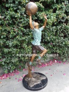 Layup bronze sculpture of life-size basketball player shooting basketball