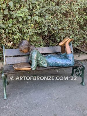 Best in Class bronze sculpture of young girl resting on bench reading her favorite novel
