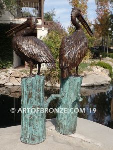 Shoreline Patrol bronze statue of playful pelicans on bronze tree stumps