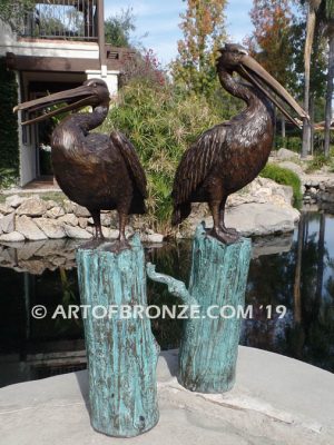 Shoreline Patrol bronze statue of playful pelicans on bronze tree stumps