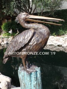 Shoreline Patrol bronze statue of playful pelicans on bronze tree stumps