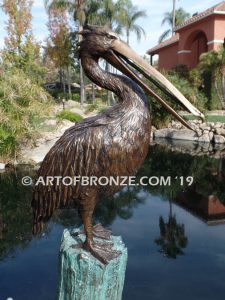 Shoreline Patrol bronze statue of playful pelicans on bronze tree stumps