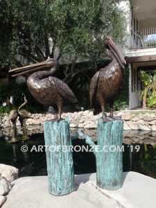 Shoreline Patrol bronze statue of playful pelicans on bronze tree stumps