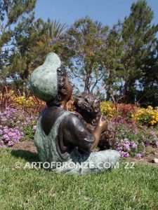 Best Buddies bronze sculpture of young boy petting his dog on his lap