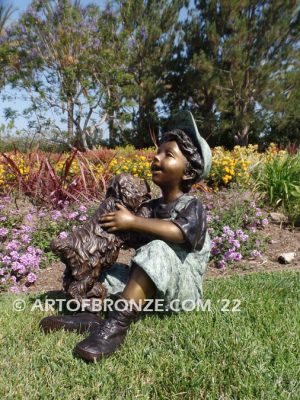 Best Buddies bronze sculpture of young boy petting his dog on his lap