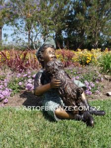 Best Buddies bronze sculpture of young boy petting his dog on his lap