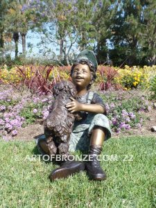 Best Buddies bronze sculpture of young boy petting his dog on his lap