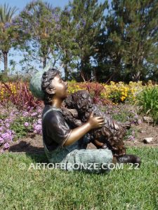 Best Buddies bronze sculpture of young boy petting his dog on his lap