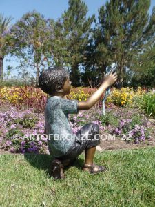 Frog Fun outdoor bronze fountain sculpture of boy grasping bullfrogs that can spray water