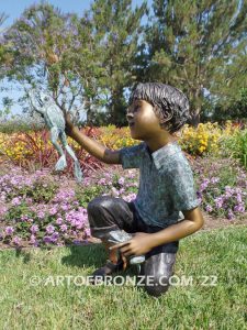 Frog Fun outdoor bronze fountain sculpture of boy grasping bullfrogs that can spray water