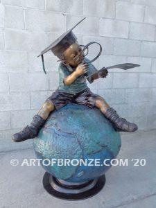 Library & elementary bronze statue of young boy reading book atop bronze world