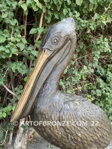 Home Pier bronze statue of playful pelican on bronze piling with rope