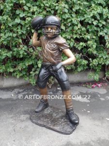 Quarterback Leader bronze sculpture of football boy wearing helmet, pads and jersey