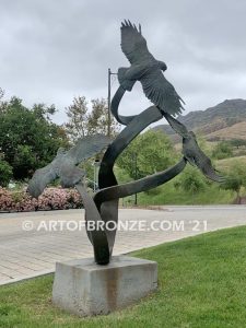 Spirit Above bronze sculpture of life-size flying hawks on bronze base for hotel entrance