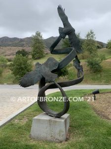 Spirit Above bronze sculpture of life-size flying hawks on bronze base for hotel entrance