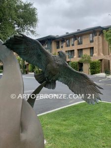 Spirit Above bronze sculpture of life-size flying hawks on bronze base for hotel entrance