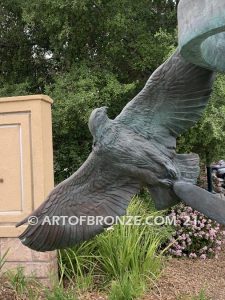 Spirit Above bronze sculpture of life-size flying hawks on bronze base for hotel entrance