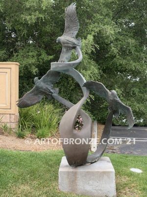 Spirit Above bronze sculpture of life-size flying hawks on bronze base for hotel entrance