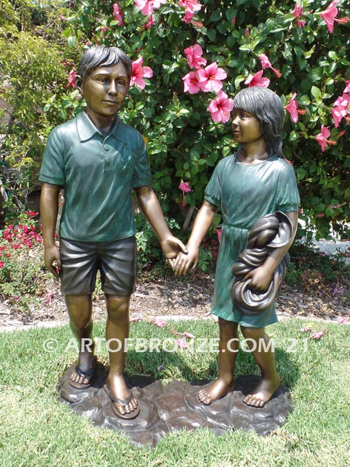 Taking a Stroll outdoor bronze sculpture brother and sister walking together holding hands