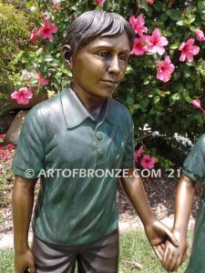 Taking a Stroll outdoor bronze sculpture brother and sister walking together holding hands