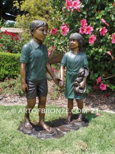 Taking a Stroll outdoor bronze sculpture brother and sister walking together holding hands