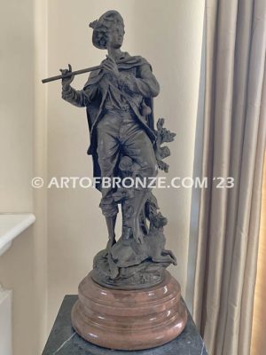 Young flautist classical bronze statue of boy holding flute with dog resting alongside