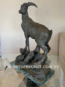 Ibex bronze sculpture standing on rocky base with large horns and rich texturing