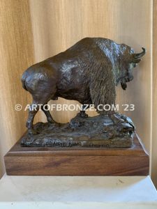 Bison bronze sculpture standing on rocky base with large horns and rich texturing