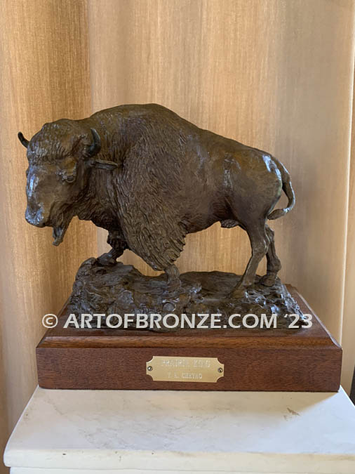 Bison bronze sculpture standing on rocky base with large horns and rich texturing