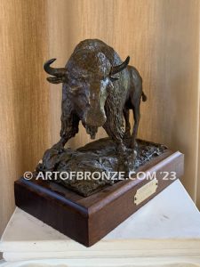 Bison bronze sculpture standing on rocky base with large horns and rich texturing