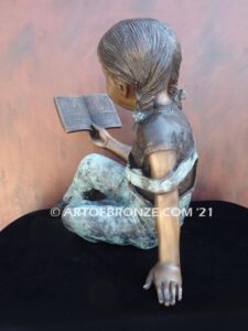 Book Smart bronze sculpture of seated girl reading book with smiling expression