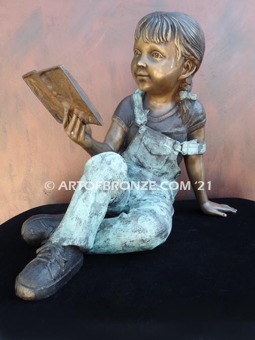 Book Smart bronze sculpture of seated girl reading book with smiling expression