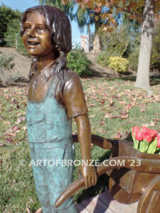 Gardening Day bronze statue of girl pulling wheelbarrow/cart for yard display