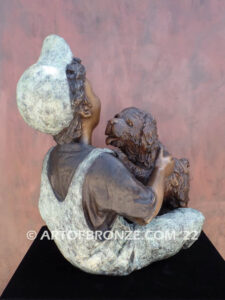 Best Buddies bronze sculpture of young boy petting his dog on his lap