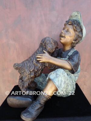 Best Buddies bronze sculpture of young boy petting his dog on his lap