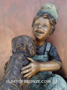 Best Buddies bronze sculpture of young boy petting his dog on his lap