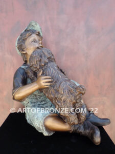 Best Buddies bronze sculpture of young boy petting his dog on his lap