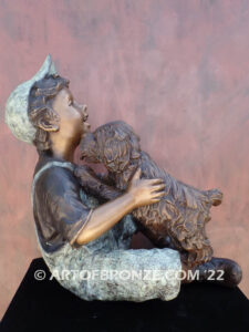 Best Buddies bronze sculpture of young boy petting his dog on his lap