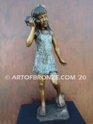 Captivating bronze fountain statue of girl standing listening to seashell