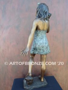 Captivating bronze fountain statue of girl standing listening to seashell