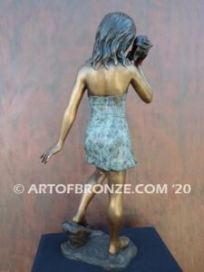 Captivating bronze fountain statue of girl standing listening to seashell