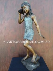 Captivating bronze fountain statue of girl standing listening to seashell