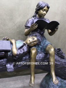 Break Time monumental bronze sculpture two children reading book on log