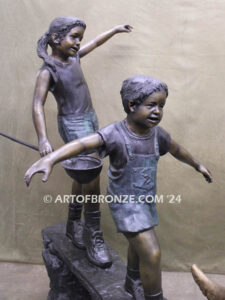 Day of Adventure bronze sculpture of two children and dog strolling across bronze log
