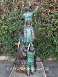 High Hopes bronze sculpture of four children playing on bronze rock for park or school playground