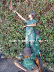 High Hopes bronze sculpture of four children playing on bronze rock for park or school playground