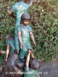 High Hopes bronze sculpture of four children playing on bronze rock for park or school playground