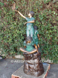 High Hopes bronze sculpture of four children playing on bronze rock for park or school playground