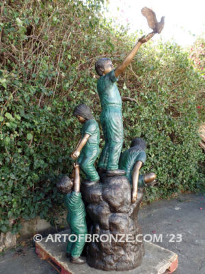 High Hopes bronze sculpture of four children playing on bronze rock for park or school playground