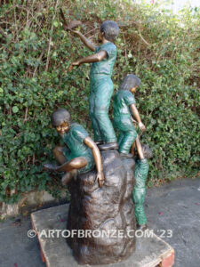 High Hopes bronze sculpture of four children playing on bronze rock for park or school playground